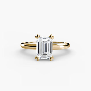 Ring with emerald-cut diamond center stone on gold-tone band